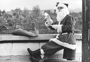 Father Christmas having a well earned cup of tea on a roof top, Teesside Father Christmas having a well earned cup of tea on a roof top, Teesside