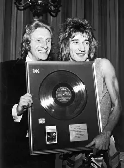 Footballer Denis Law presents singer Rod Stewart of The Faces with a gold disc to mark Footballer Denis Law presents singer Rod Stewart of The Faces with a gold disc to mark