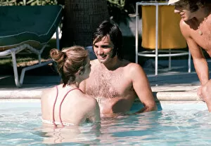 Images Dated 12th February 1972: Footballer George Best relaxes with girlfriend Linda Joinett in a swimming pool in Palm