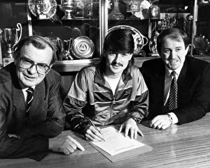 Images Dated 1st January 1987: Footballer Ian Snodin pictured signing for Everton watched by manager Howard Kendall