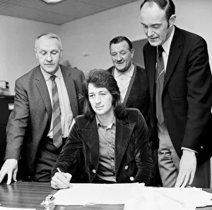 Frank Worthington signs for Liverpool from Huddersfield Town at Anfield watched by Frank Worthington signs for Liverpool from Huddersfield Town at Anfield watched by