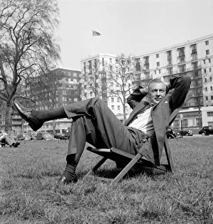 Gary Cooper sitting on a deck chair in London - April 1955 English flag in Gary Cooper sitting on a deck chair in London - April 1955 English flag in