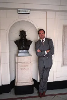 George Graham former Arsenal manager next to a bust of Herbert Chapman in marble hall of George Graham former Arsenal manager next to a bust of Herbert Chapman in marble hall of