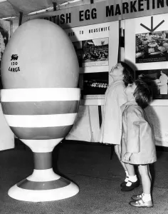 A giant egg brings amazement and wonder to the faces of two children at the British Egg A giant egg brings amazement and wonder to the faces of two children at the British Egg