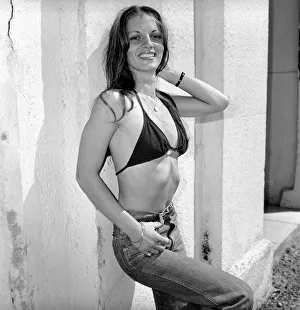 A glamour model wearing a bikini top and jeans April 1975 A glamour model wearing a bikini top and jeans April 1975