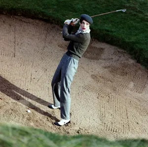 Golf Fashion female golfer in bunker grey trousers Golf Fashion female golfer in bunker grey trousers