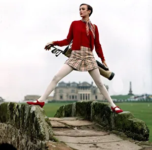 Golf Fashion woman standing astride stone humpback bridge Red shoes twin set jumper Golf Fashion woman standing astride stone humpback bridge Red shoes twin set jumper