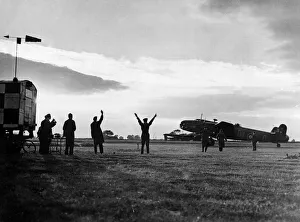 The group captain commanding officer of an RAF station signals a Halifax bomber to begin The group captain commanding officer of an RAF station signals a Halifax bomber to begin