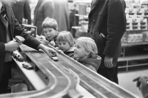 A group of children look on longingly at the latest Scalextric slot car racing set in A group of children look on longingly at the latest Scalextric slot car racing set in
