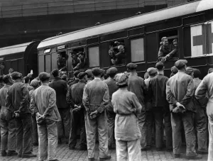 A group of workmen cheering some of the repatriated and wounded prisoners who were able A group of workmen cheering some of the repatriated and wounded prisoners who were able