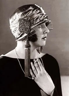 Hat fashion - April 1924 Woman wearing elaborate hat with tassles Hat fashion - April 1924 Woman wearing elaborate hat with tassles