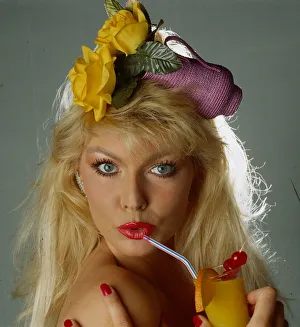 Hat fashion model wears straw hat in shape of purple jug with yellow roses July 1990 Hat fashion model wears straw hat in shape of purple jug with yellow roses July 1990