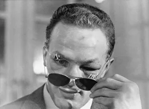 Henry Cooper, the new British and Empire Heavyweight boxing champion looks from behind Henry Cooper, the new British and Empire Heavyweight boxing champion looks from behind
