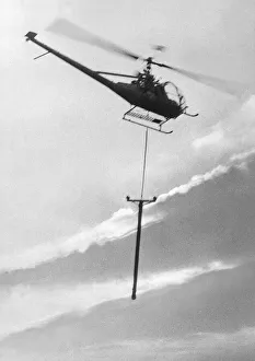 A Hiller 12E helicopter carries a telegraph pole across Grouse Moor at Kings Law A Hiller 12E helicopter carries a telegraph pole across Grouse Moor at Kings Law