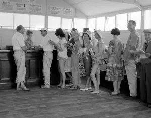Holidaymakers line up to make a bet at a betting shop in the form of a wooden chalet Holidaymakers line up to make a bet at a betting shop in the form of a wooden chalet