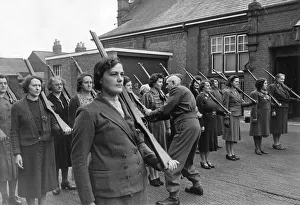 A Home Guard Sergeant giving women instructions on holding rifles during a drill A Home Guard Sergeant giving women instructions on holding rifles during a drill
