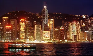 Hong Kong skyline seen from the harbour at night. The buildings are lit up for Hong Kong skyline seen from the harbour at night. The buildings are lit up for
