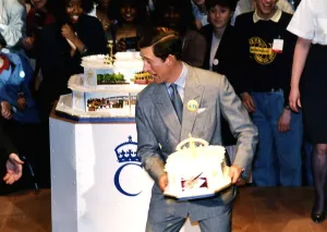HRH Prince Charles about to throw a birthday cake to a crowd of onlookers during his HRH Prince Charles about to throw a birthday cake to a crowd of onlookers during his