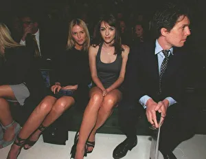 Hugh Grant actor with girlfriend Liz Hurley sits on bench to watch the Versace fashion Hugh Grant actor with girlfriend Liz Hurley sits on bench to watch the Versace fashion