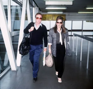 Jackie Collins Writer walking through Heathrow airport with Michael Caine Jackie Collins Writer walking through Heathrow airport with Michael Caine