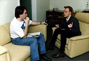 Jason Donovan being interviewed black jeans jacket sitting in armchair ankle boots Jason Donovan being interviewed black jeans jacket sitting in armchair ankle boots