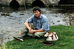 Jeremy Paxman tv presenter of Newsnight and journalist with his fishing gear on riverbank Jeremy Paxman tv presenter of Newsnight and journalist with his fishing gear on riverbank