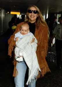 Jerry Hall Supermodel and Actress walking through Heathrow Airport carrying her daughter Jerry Hall Supermodel and Actress walking through Heathrow Airport carrying her daughter