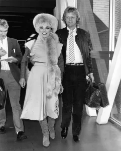 Joan Collins British Actress at Heathrow Airport with boyfriend Peter Holm in October Joan Collins British Actress at Heathrow Airport with boyfriend Peter Holm in October