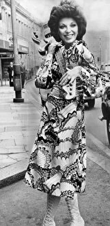 Images Dated 1st May 1970: Joan Collins carrying electric guitar at the Extravaganza 70s fashion exhibition at