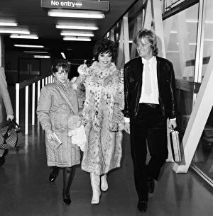 Images Dated 22nd December 1983: Joan Collins with daughter Katyana Kass and boyfriend Peter Holm at Heathrow after