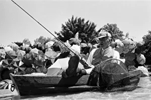 Joe Carver, owner of an umbrella making business, sits in a fishing boat smoking a cigar Joe Carver, owner of an umbrella making business, sits in a fishing boat smoking a cigar