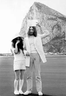 John Lennon holds his marriage certificate above his head as he stands with his new wife John Lennon holds his marriage certificate above his head as he stands with his new wife