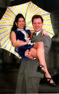 Kathryn Dixon being lifted by John Leslie holding yellow and white striped umbrella Kathryn Dixon being lifted by John Leslie holding yellow and white striped umbrella
