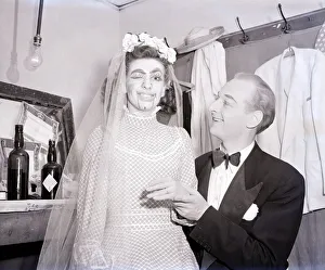 A lady wears make-up to make her look like a ventriloquists dummy sits on a mans lap in a A lady wears make-up to make her look like a ventriloquists dummy sits on a mans lap in a
