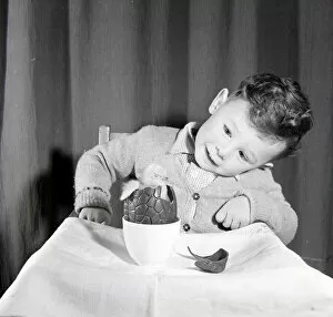 Images Dated 4th November 2005: Little boy with chick in chocolate Easter egg. Circa 1960