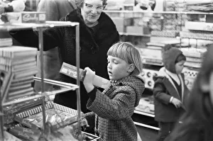 A little girl checks out the latest Sindy doll in the toy department of Heelas Department A little girl checks out the latest Sindy doll in the toy department of Heelas Department
