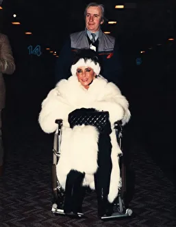 Liz Taylor is pushed through Heathrow airport ijn a wheelchair Liz Taylor is pushed through Heathrow airport ijn a wheelchair
