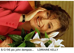 Lorraine KELLY next to a green white plant red jacket watch Lorraine KELLY next to a green white plant red jacket watch
