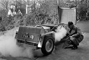 Man driving a steam powered car near his home December 1970 70-11615-002 Man driving a steam powered car near his home December 1970 70-11615-002