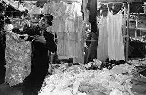 A market trader modelling ladies underwear to gain a sales in Kingston Market circa 1936 A market trader modelling ladies underwear to gain a sales in Kingston Market circa 1936