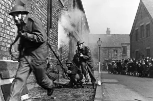 Members of the Home Guard running through a training exercise in a residential street in Members of the Home Guard running through a training exercise in a residential street in
