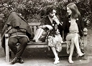 Men dressed as women sitting on a park bench as they take a break from the gay pride Men dressed as women sitting on a park bench as they take a break from the gay pride