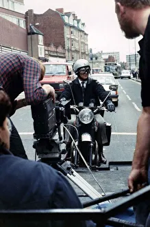 Michael Elphick actor sitting on motor bike attached rig on the back of lorry filming for Michael Elphick actor sitting on motor bike attached rig on the back of lorry filming for