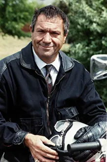 Michael Elphick sitting on motorcycle holding crash helmet Michael Elphick sitting on motorcycle holding crash helmet