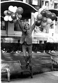 Images Dated 18th December 1982: Millionaire airline owner Freddie Laker holding a bunch of balloons after bouncing back