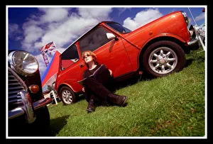 Mini car August 1999 Woman sitting leaning against red Mini in the sun reading brochure Mini car August 1999 Woman sitting leaning against red Mini in the sun reading brochure