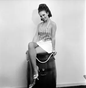 00027 Prints: Woman in patterned top and short skirt poses with a barrel, 1969 Print