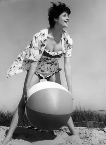 Vintage Beachwear Prints: Clothing Beach. Model wears floral shirt with matching swimsuit swimming costume