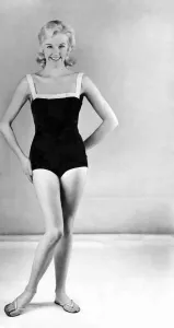 Woman In Swimsuit Prints: Reveille Fashions. Model wearing a one piece swimming costume and flip flop shoes