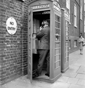 00058 Prints: Man using a Red Telephone Box Print, April 1975